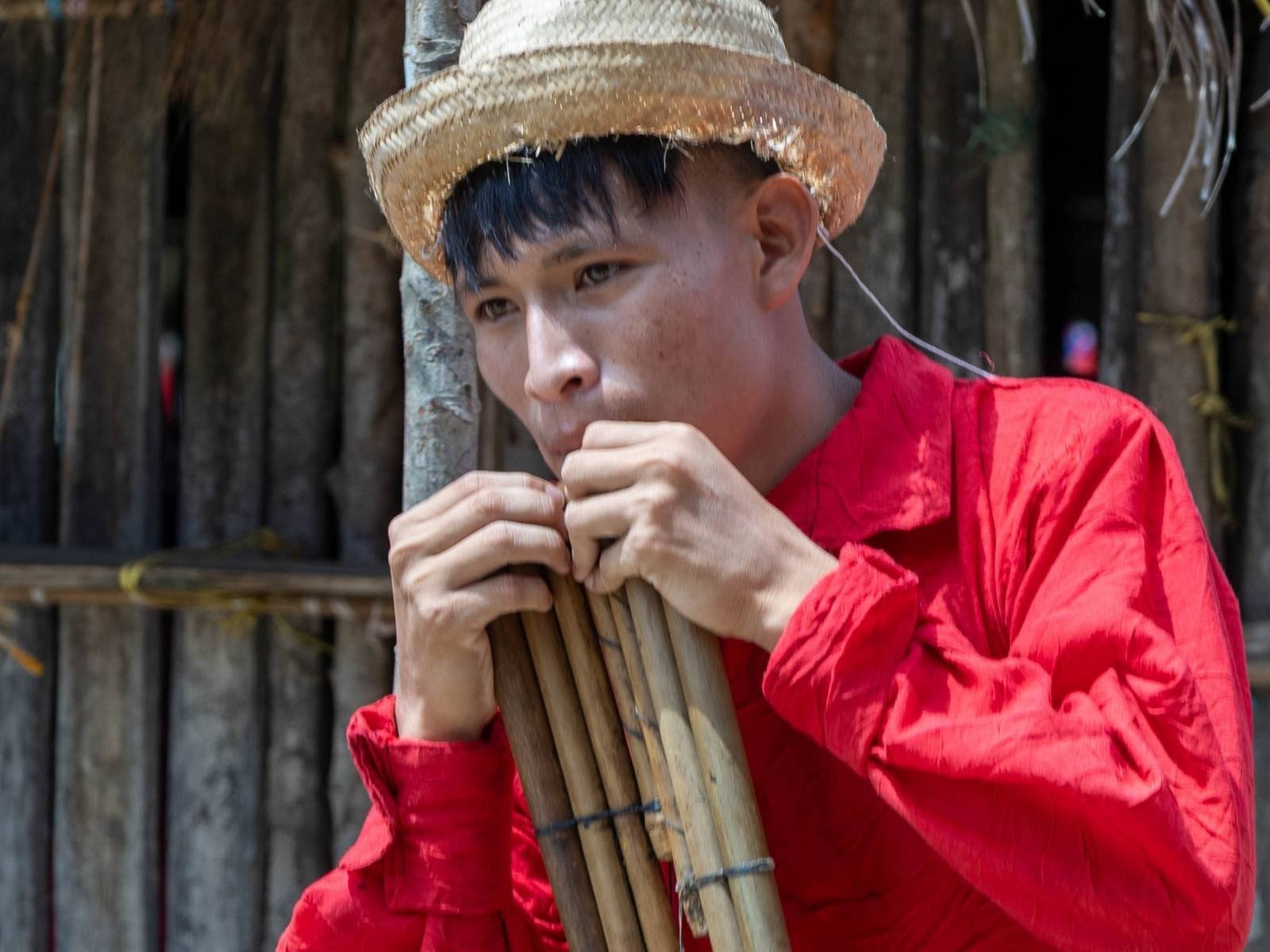 Guna man playing traditional musical instrument in indigenous community San Blas Panama