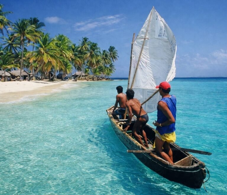 Cayuco tradicional Guna navegando a vela en San Blas Panamá con aguas cristalinas