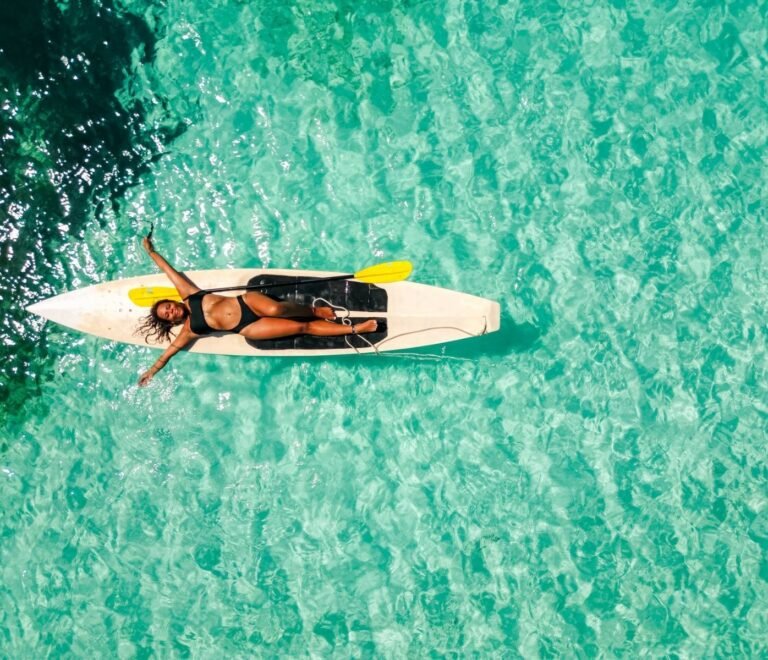Traveler paddleboarding on crystal clear waters in San Blas Islands Panama