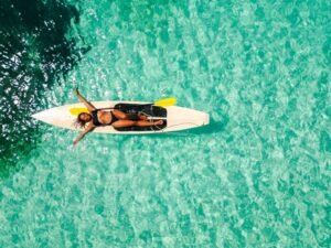 Aguas cristalinas turquesas en San Blas Panamá con persona en paddle board