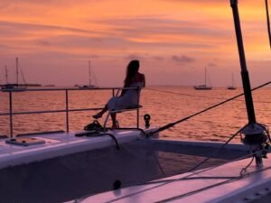 Guest relaxing on SunReef 62 catamaran net at sunset in San Blas Panama