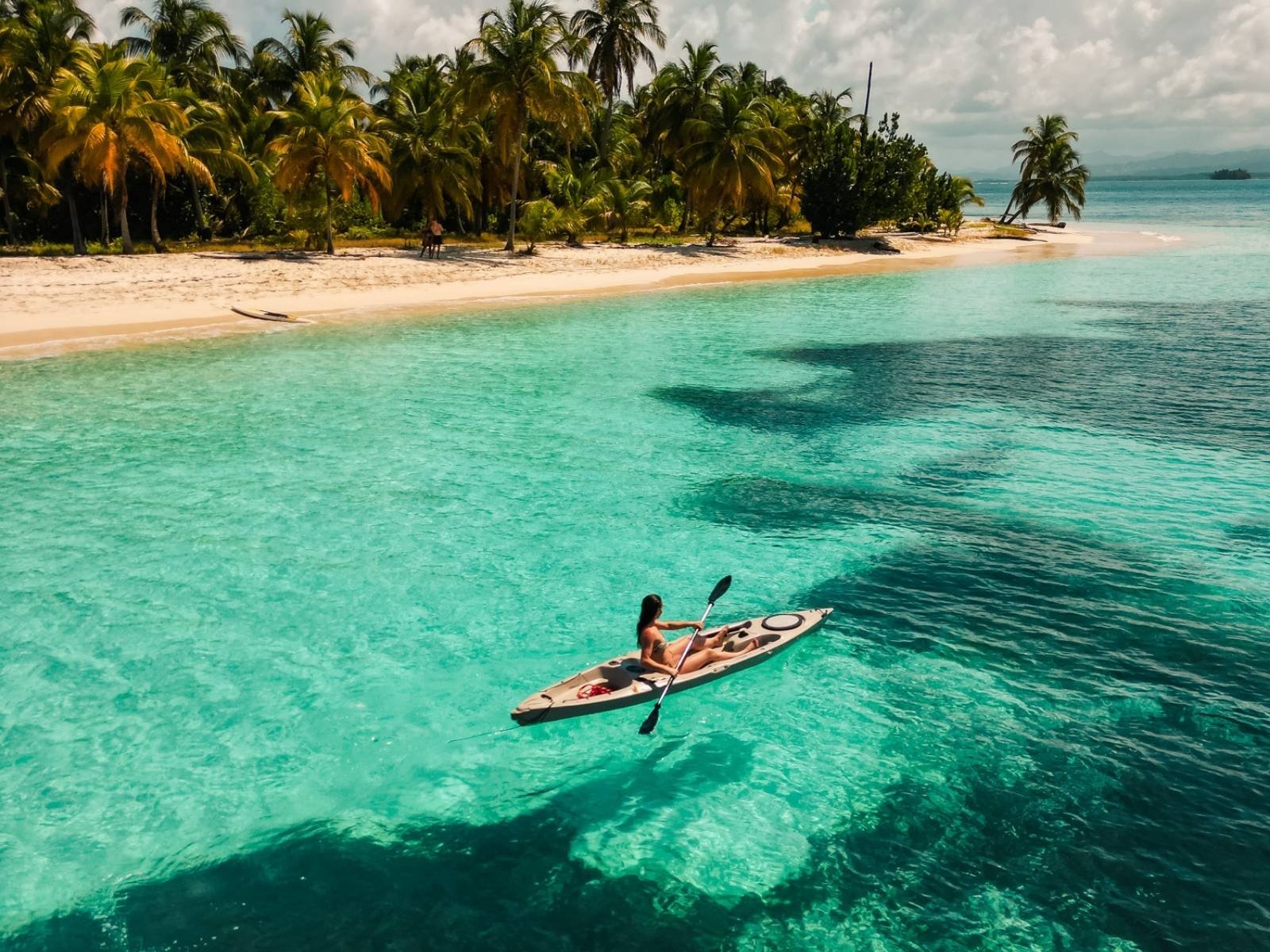 Persona haciendo kayak en aguas turquesas durante un pasadía en San Blas