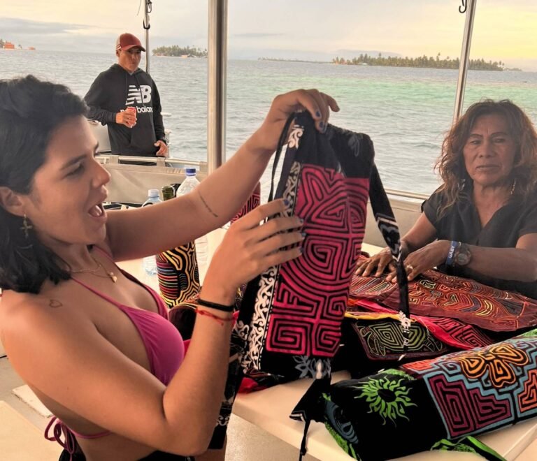 Venta de molas tradicionales por artesanas locales durante un pasadía en catamarán en San Blas