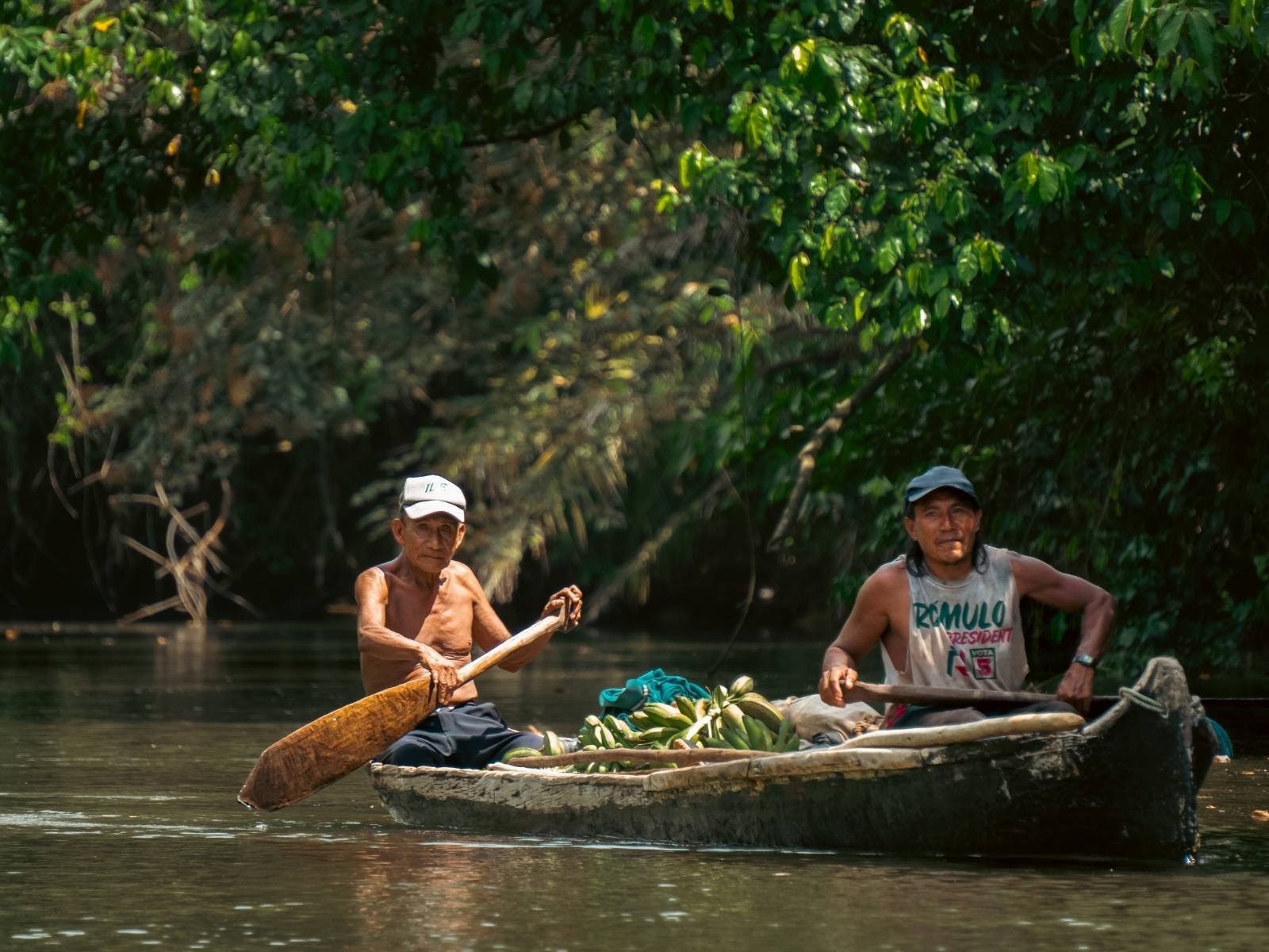 Guna indigenous man paddling traditional wooden cayuco in San Blas Islands Panama