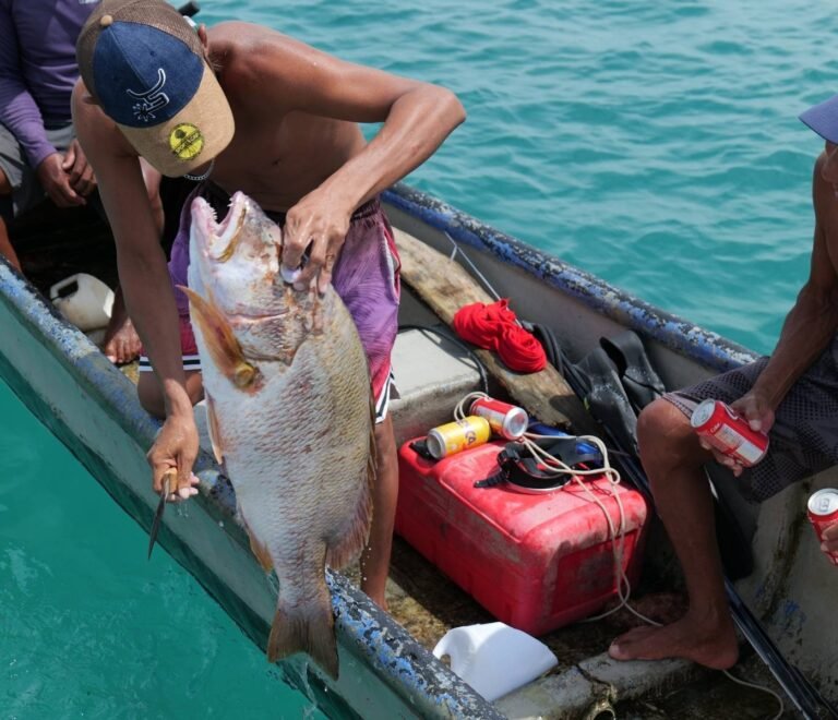 Guna fisherman selling fresh red snapper catch of the day in San Blas Islands Panama