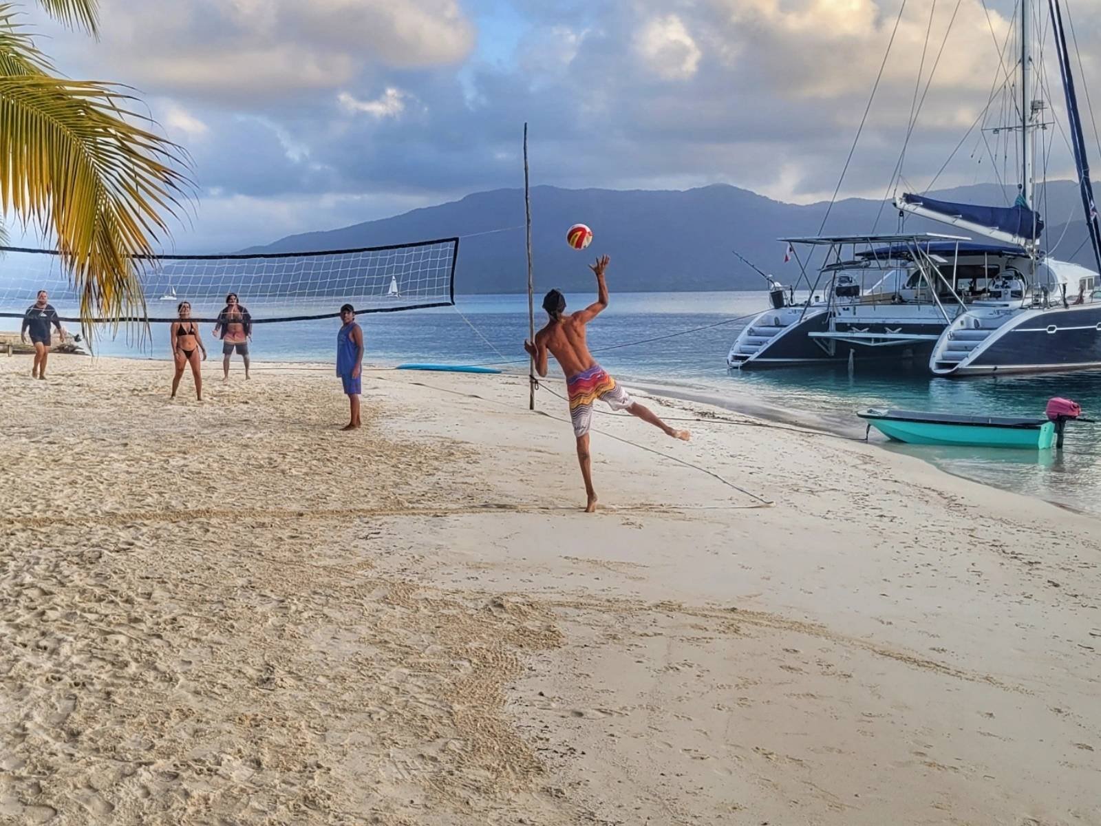 Beach volleyball near Lagoon 57 catamaran anchored on island beach in San Blas
