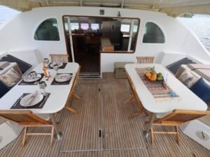 Cockpit exterior de catamarán Lagoon 57 en San Blas con mesas y zona de descanso frente al mar