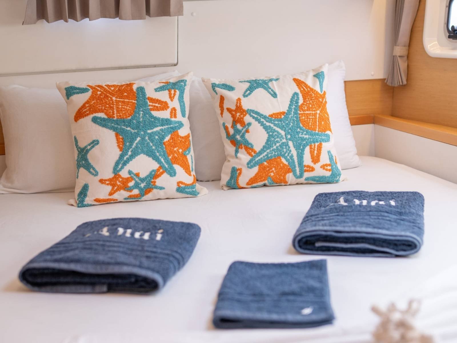 detalle de cama en catamaran Lagoon 40 en San Blas con almohadas decoradas y toallas organizadas