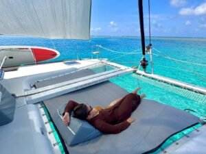 Guest relaxing on front net of Lagoon 400 DO catamaran in San Blas