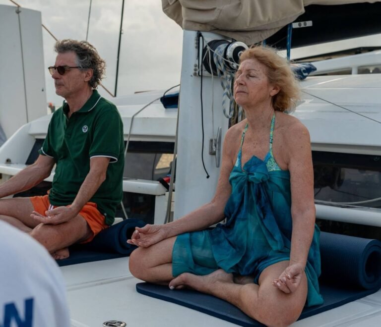 Guests meditating onboard catamaran wellness retreat in San Blas Panama