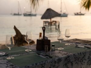 Cena romántica en la playa de San Blas al atardecer con mesa privada frente al mar Caribe en Panamá