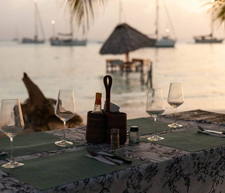 Cena romántica en la playa de San Blas al atardecer con mesa privada frente al mar Caribe en Panamá