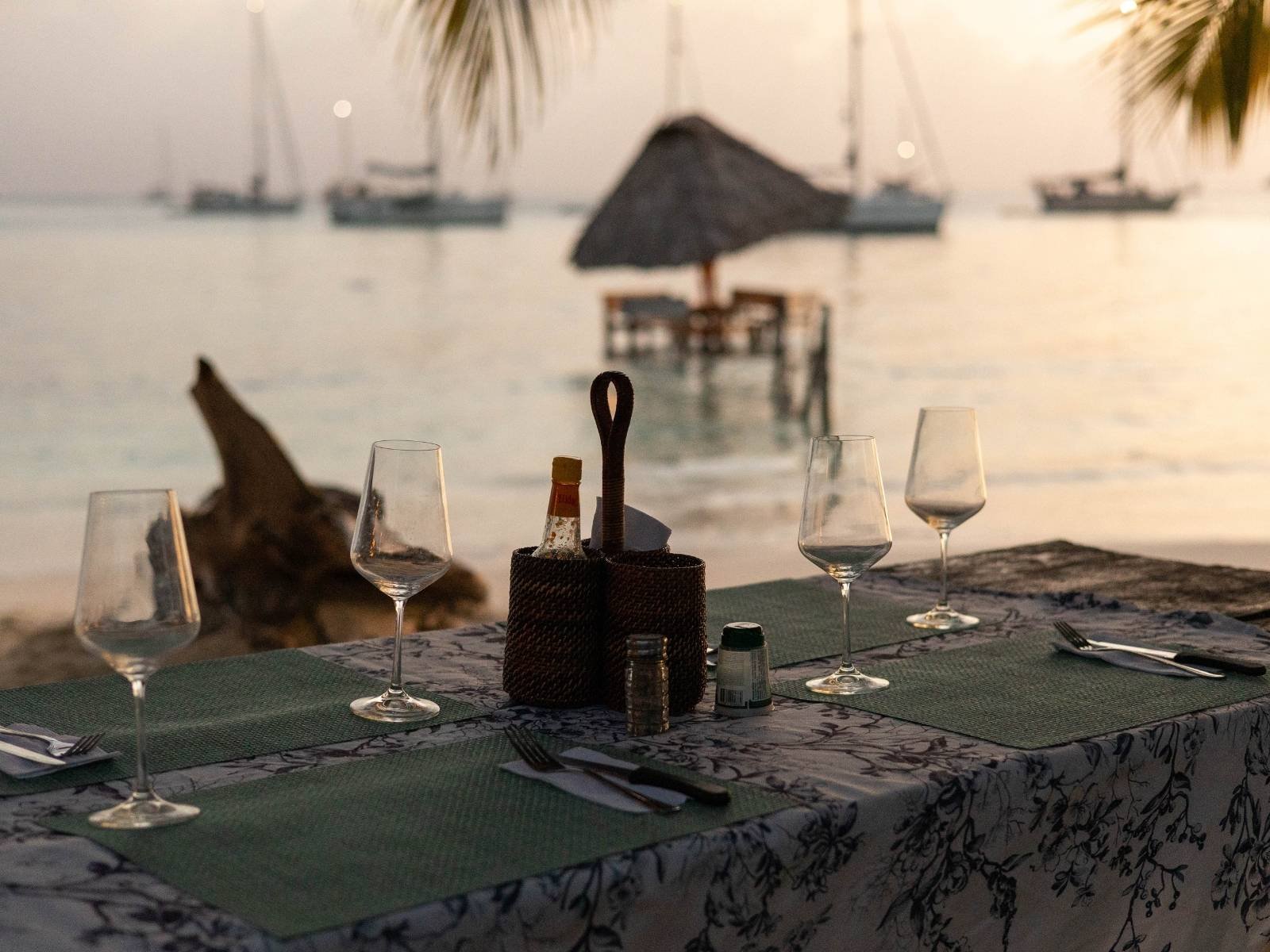 Cena romántica en la playa de San Blas al atardecer con mesa privada frente al mar Caribe en Panamá