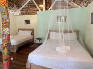 Cabaña deluxe en Cayos Holandeses San Blas con dos camas amplias y mosquitero en interior cómodo