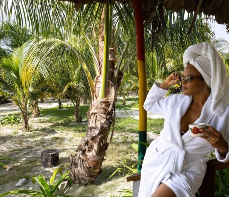 Persona disfrutando café al amanecer en Cayos Holandeses San Blas rodeada de palmeras
