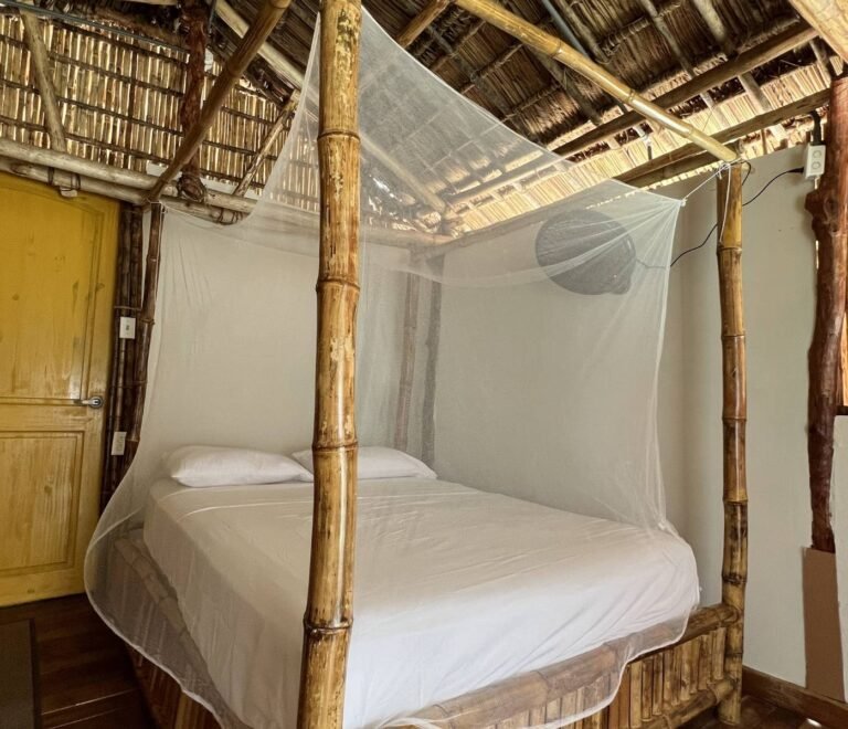 Private bedroom with mosquito net inside bungalow cabin in Dutch Cays