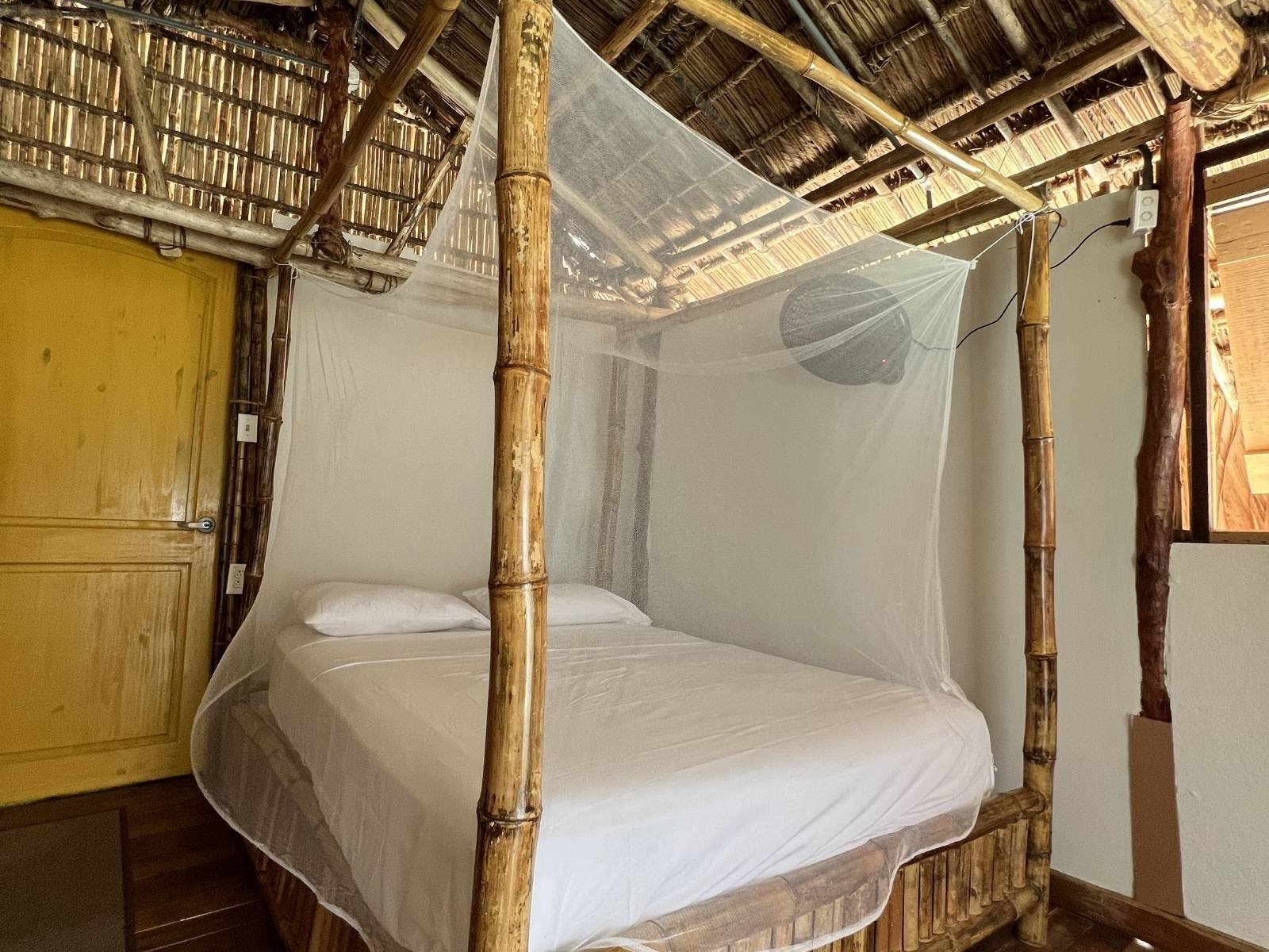 Private bedroom with mosquito net inside bungalow cabin in Dutch Cays