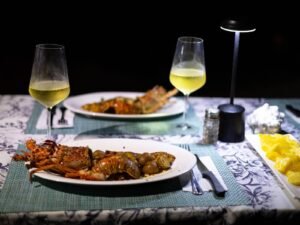 Cena de langosta en San Blas Panamá con platos de mariscos y vino en mesa frente al mar