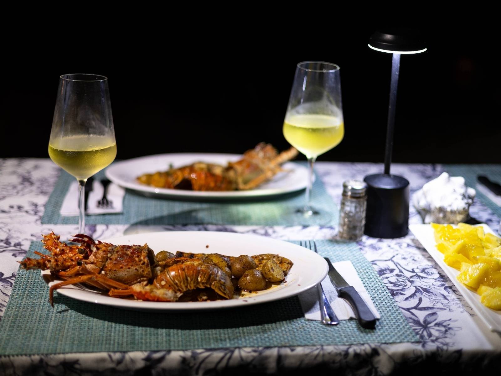 Cena de langosta en San Blas Panamá con platos de mariscos y vino en mesa frente al mar