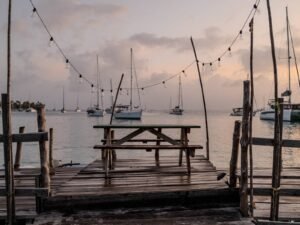 Cena romántica en muelle en San Blas al atardecer con mesa frente al mar y luces cálidas