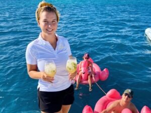 Guest holding welcome drinks onboard Lagoon 55 catamaran in San Blas
