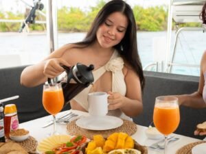 persona disfrutando desayuno a bordo de catamaran Lagoon 40 en San Blas con jugo y comida fresca