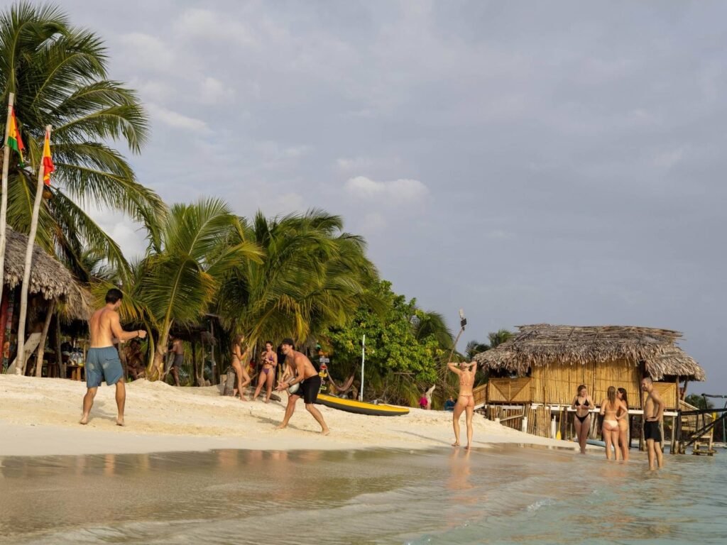 Turistas disfrutando la playa de arena blanca en las Islas San Blas, Guna Yala, Panamá