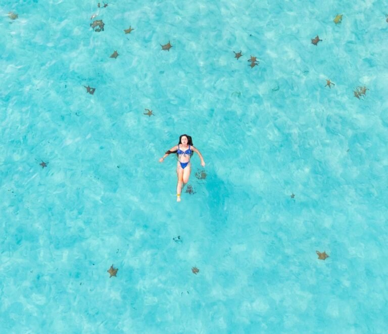 Guest floating in crystal clear waters of Dutch Cays San Blas aerial view