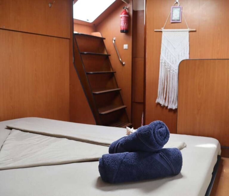 Camarote de catamarán en San Blas con ropa de cama limpia y toallas preparadas sobre la cama