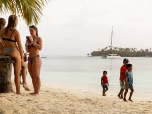 Familias y turistas en playa de Cayos Holandeses San Blas con niños disfrutando el mar Caribe