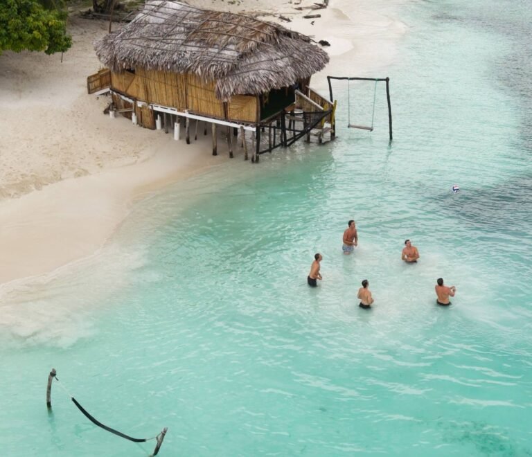 Guests swimming in turquoise waters near bungalow in Dutch Cays San Blas